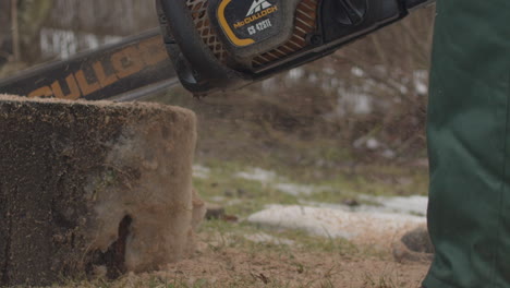 Close-up-shot-of-a-woodworker-cutting-a-log-with-a-chainsaw