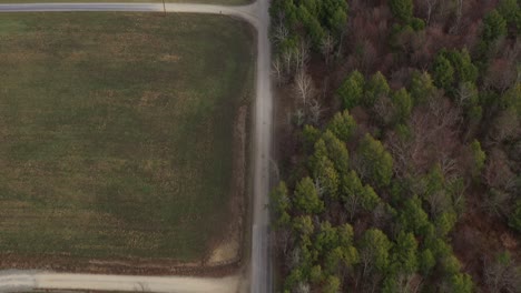 Aerial-drone-bird's-eye-view-flight-over-houses,-farmland,-forest,-green-fields-and-roads-on-an-autumn-day-in-rural-Rome,-Pennsylvania