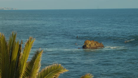 Surfistas-En-El-Océano-Esperando-Olas-Cerca-Del-Acantilado