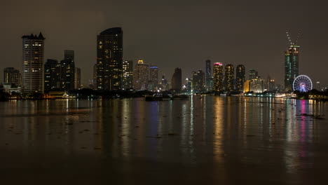 Ruhige,-Dunkle-Nachtlandschaft-Am-Fluss-Bangkok-Chao-Phraya-Mit-Booten,-Wolkenkratzern-Und-Skyline