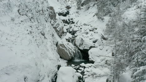 Flying-towards-small-waterfalls-in-snow-covered-wilderness