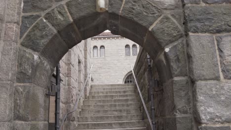 Stairs-under-ancient-stone-arch-in-The-Cloisters,-New-York