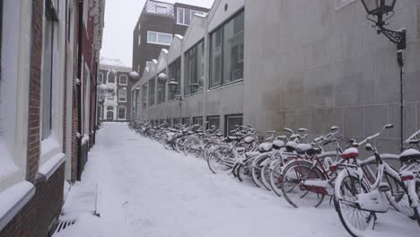 Dutch-city-bicycles-covered-in-heavy-winter-snow,-Leiden-Netherlands