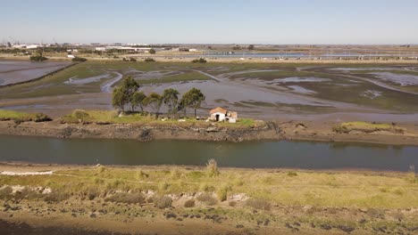 4K-aerial-view-of-a-house-in-the-middle-of-some-artificial-lagoons-in-Ria-de-Aveiro-with-drone-moving-to-the-left,-60fps