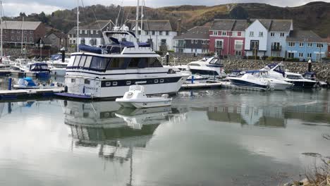 Small-fishing-boat-cruising-between-yachts-in-Luxury-Conwy-marina-North-Wales-waterfront