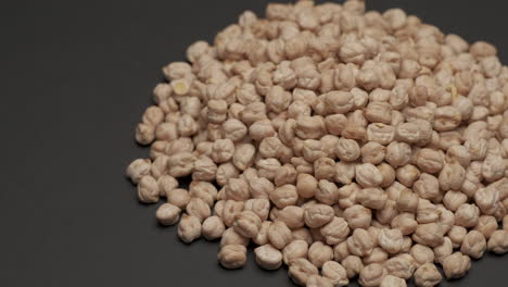 Dry-raw-uncooked-chickpeas-legumes-rotating-on-black-background