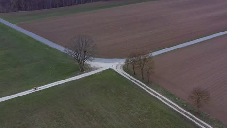 Rural-crossing-from-high-above-with-a-bicycle-rider-coming-from-the-left-arm,-riding-to-the-upper-one-out-of-the-frame