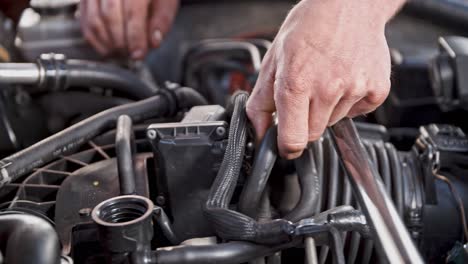 Strong-male-hands-fixing-car-motor-in-close-up-view
