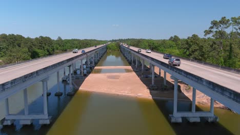 Antena-De-Autos-Circulando-Por-El-Puente-Que-Cruza-El-Río-San-Jacinto-En-Houston,-Texas