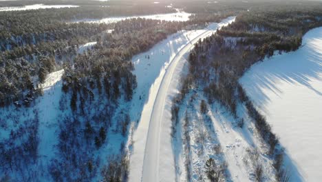 Paisaje-Invernal-De-árboles-En-El-Bosque,-La-Carretera-Y-El-Arroyo-Congelado-En-Laponia,-Finlandia