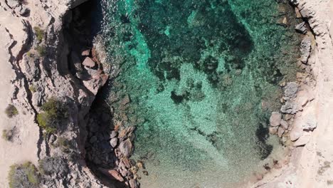 Wunderschöne-Luftaufnahme-Eines-Türkisfarbenen-Strandes-In-Ibiza,-Spanien