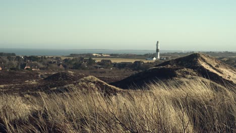 Dünen-Auf-Sylt-An-Einem-Windigen-Tag-Mit-Dem-Leuchtturm-„Langer-Christian“-Und-Der-Nordsee-Im-Hintergrund