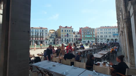 Restaurante-De-Turistas-Con-Mucha-Gente-Comiendo-Y-Bebiendo-Para-El-Almuerzo-Durante-Un-Hermoso-Día-Soleado-En-Italia