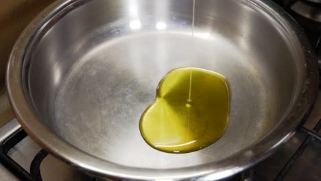 Olivenöl-Aus-Der-Ölflasche-In-Einen-Silbernen-Metalltopf-Gießen,-In-Nahaufnahme
