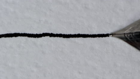 Nahaufnahme-Eines-Füllfederhalters,-Der-Eine-Gerade-Tintenlinie-Auf-Einer-Strukturierten-Papieroberfläche-Zeichnet