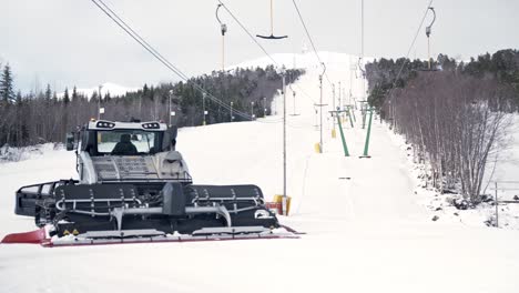 Snowcat-driving-over-ski-slopes,-preparing-the-slopes