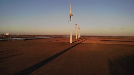 Towering-Windmills-On-Green-Fields-Against-Blue-Sky-At-Dusk-In-Nieuw-Beijerland,-Netherlands