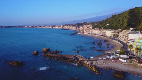 A-drone-flies-along-the-coast-of-Catania-accross-the-bright-blue-Mediterranean-sea
