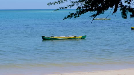 Canoa-De-Pesca-De-Pescadores-De-Madera-Verde-Y-Amarillo-Timorense-Tradicional-En-Solitario-En-La-Remota-Isla-Tropical-De-Timor-Leste,-Sudeste-De-Asia