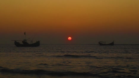 Silhouette-of-fishing-boats-parked-on-sea-during-golden-hour