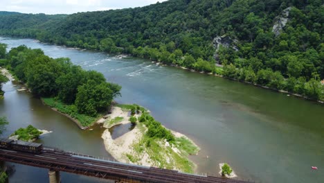 The-Potomac-River-near-Harper's-Ferry,-West-Virginia-as-a-train-crosses-the-river-on-a-bridge