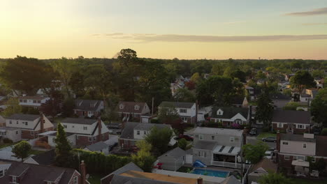 An-aerial-view-over-a-middle-class-suburban-neighborhood-on-Long-Island,-NY-at-sunrise