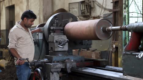 A-man-working-on-Lathe-Machine-and-shaping-the-iron-in-Tools