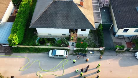 AERIAL---Firefighters-and-hose-at-a-fire-in-Oberwaltersdorf,-Austria