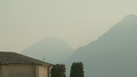 Full-shot,-Cross-on-the-top-of-a-Church-in-Malcesine,-dusk-and-sunset-in-the-background