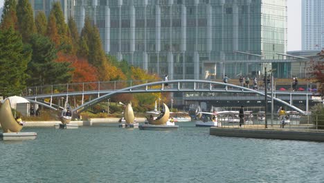 Incheon-Songdo-Central-Park---Koreans-in-protective-masks-travel-on-Family-Boats-and-Moon-catamaran-vessels-at-the-lake-and-walk-across-footbridge-during-covid-19-coronavirus-in-South-Korea