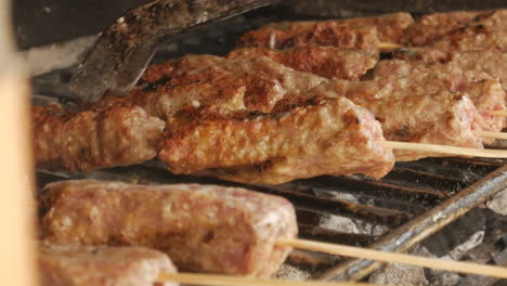 Nahaufnahme-Des-Chefkochs,-Der-Mici-Traditionellen-Rumänischen-Kebab-Auf-Dem-Grill-Zubereitet