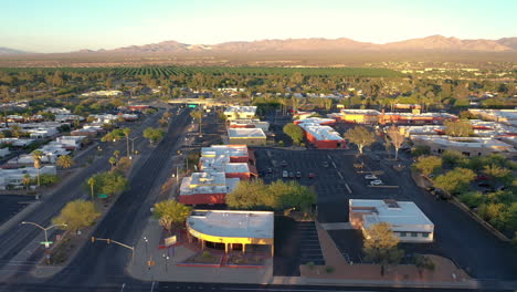 Drone-flying-over-local-businesses-in-Green-Valley-at-sunset,-Arizona