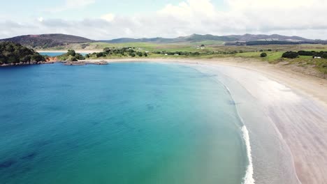 Aerial-drone-of-the-stunning-curved-beach-of-Maitai-Bay,-Karikari-Peninsula,-Northland,-New-Zealand-Aotearoa