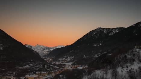 TIME-LAPSE---Town-in-a-valley-in-the-Pyrenees,-day-to-night,-wide-shot-tilt-down