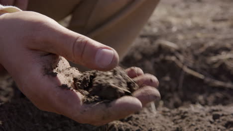 Man's-hand-sifting-through-soil,-preparing-for-planting,-agriculture,-close-up