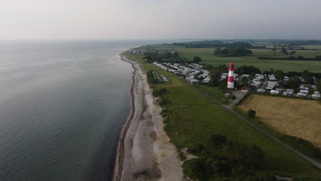 Luftaufnahme-Eines-Strandes-In-Norddeutschland-An-Einem-Sommertag-Mit-Leuchtturm-Und-Campingplatz