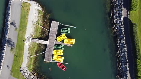 Small-seawater-pond-inside-breakwater-and-kayaks-laying-on-lawn-ready-for-use---Birdseye-aerial-of-Loen-shoreline-with-sports-equipment---Norway