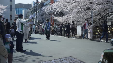 Traffic-Officer-Directing-On-The-Street-With-Many-People-During-Hanami-Event-In-City-Of-Tokyo,-Japan