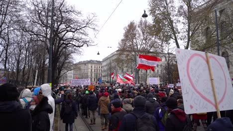 Massive-crowd-of-protestors-marching-down-street-in-Vienna,-Austria