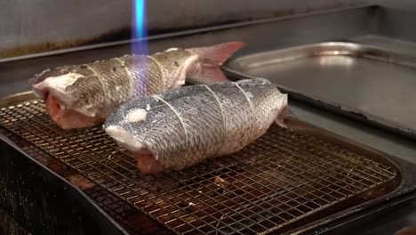 Chef-Profesional-Usando-Pescado-Braseado-Con-Soplete,-Cocinando-Rollito-De-Pescado-Con-Relleno-De-Salmón