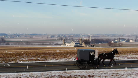 Antena-Junto-A-Buggy-Amish-Tirado-Por-Caballos-Durante-La-Nieve-Del-Invierno