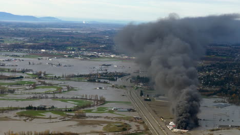 Vista-Aérea-Del-Incendio-Del-Patio-De-Almacenamiento-Y-El-Paisaje-Inundado-De-Abbotsford-En-Columbia-Británica,-Canadá