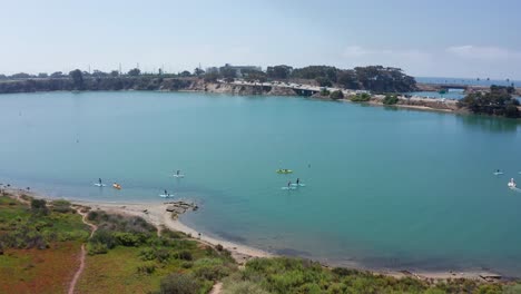 Aerial-shot-flying-over-kayakers-on-the-Carlsbad-lagoon-recreational-area,-America