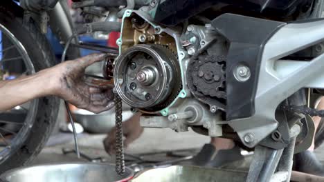 Mechanics-repairing-inner-parts-of-motorbike-engine,-static-close-up-view