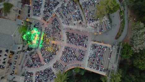 Aerial-view-of-a-artist-performing-at-a-crowded-outdoor-venue-in-California---top-down,-drone-shot