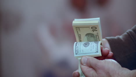 Slow-motion-medium-shot-of-a-person-holding-a-bundle-of-prop-money-as-they-flip-through-the-bills