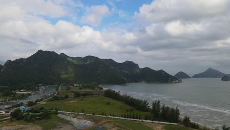 Aerial-footage-sliding-to-the-right-revealing-a-fishing-village-and-the-beach-front-at-an-estuary-in-Khao-Sam-Roi-Yot-National-Park,-Prachuap-Khiri-Khan,-Thailand