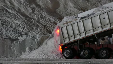 Camión-Volquete-Descargando-Un-Montón-De-Nieve-Durante-La-Noche-Después-De-Una-Tormenta-De-Invierno