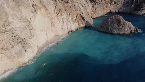 Narrow-secluded-beach-with-azure-blue-water-next-to-rugged-cliff---Mediterranean