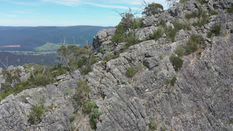 Students-abseil-and-climb-on-craggy-Sugarloaf-mountain-peak,-Victoria